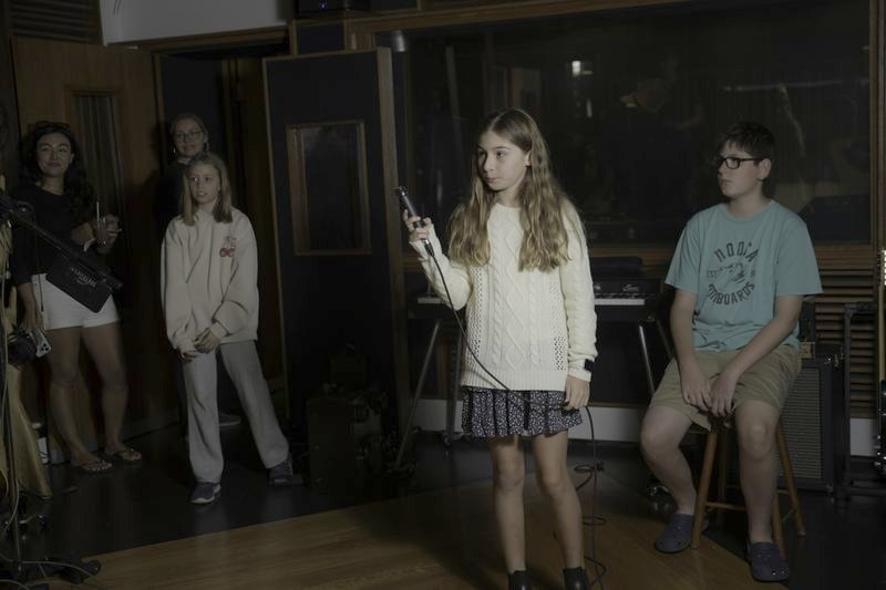 A student performing to an audience in the studio