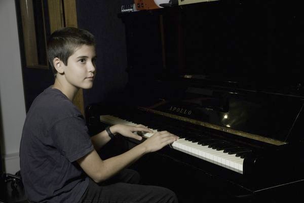 A student playing piano in the studio