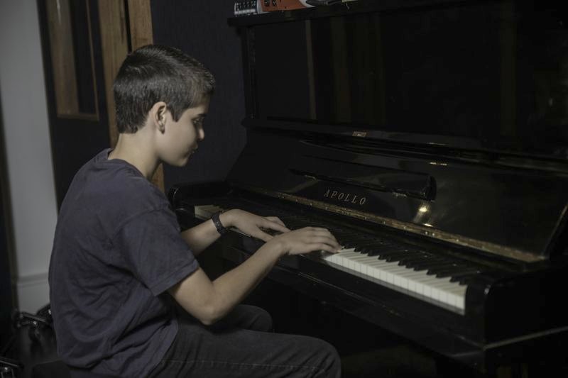 A student playing piano in the studio
